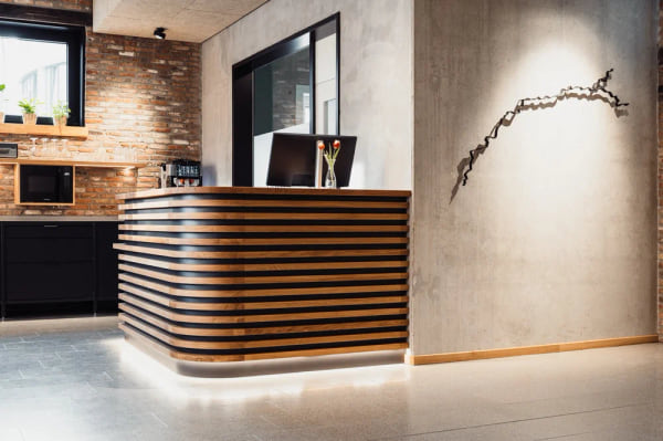 Die Lobby des Baltica Hamburg Altona mit langem Holztisch und Sitzgelegenheiten